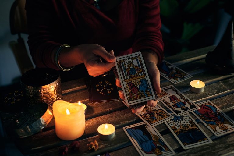 a-pythoness-shows-tarot-cards-on-a-wooden-table