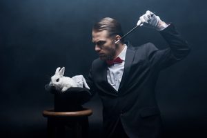 concentrated-magician-in-suit-showing-trick-with-w